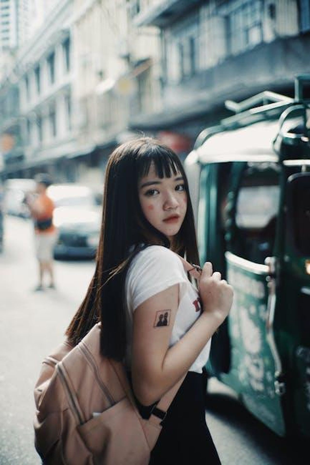Impatto_del_divieto_sulle_sessioni_turistiche_S601awhaKT - Veicoli24 Source: Ike louie Natividad - pexels - Young woman walking with backpack through lively city street, capturing travel vibe.