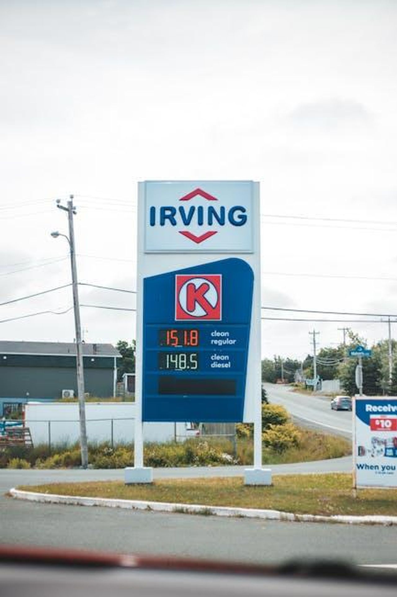 Impatto_delle_tariffe_sui_prezzi_delle_auto_aTTD5qM2Zp - Veicoli24 Source: Erik Mclean - pexels - Vertical shot of a gas station sign showing fuel prices, including Irving branding.