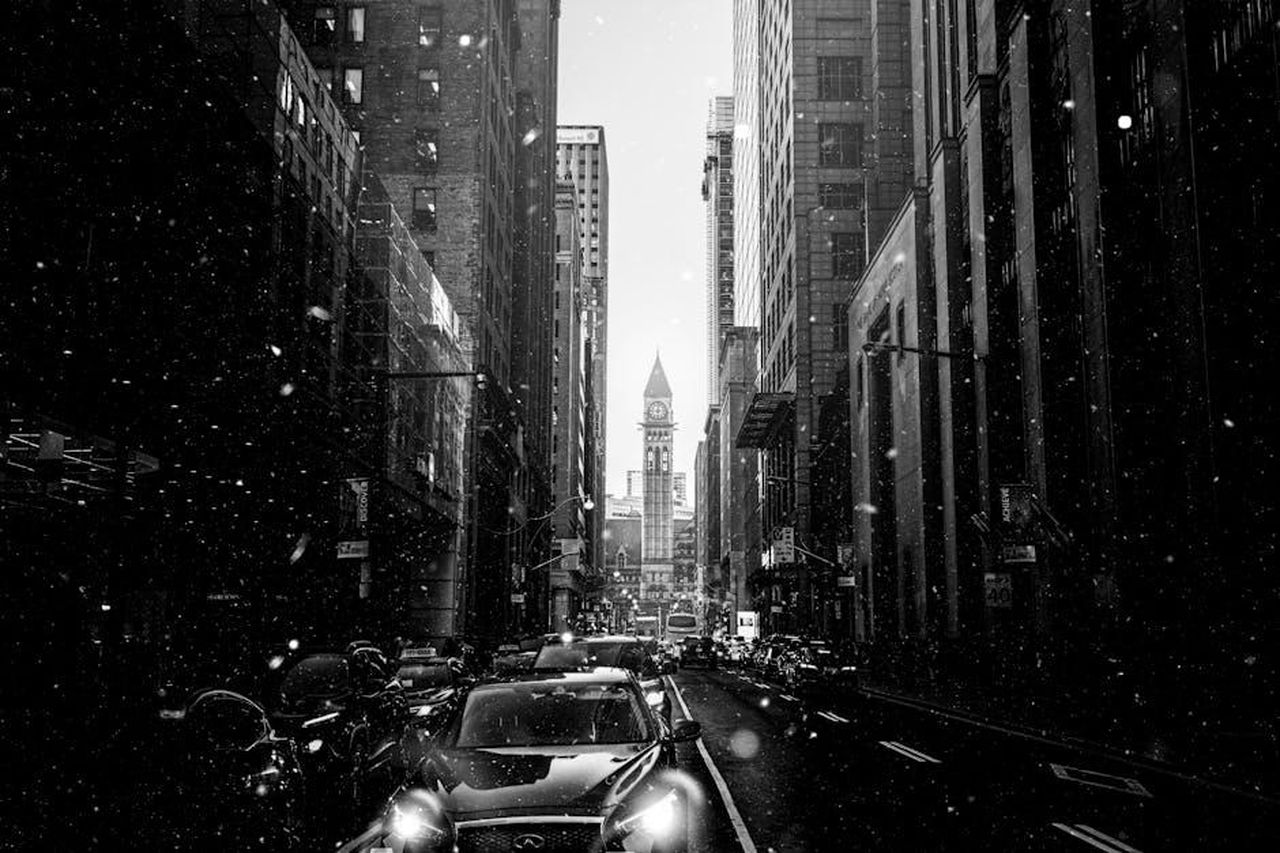 Impatto_delle_tariffe_sulle_auto_importate_0vLjieFAt8 - Veicoli24 Source: Andre Furtado - pexels - Black and white urban view of Toronto with snowfall and prominent skyscrapers.