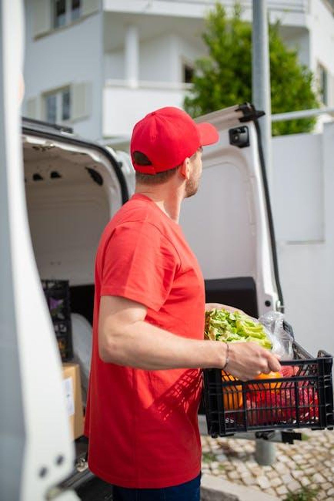 Inizio_delle_consegne_del_Gravity_SUV_prUWm1YZEY - Veicoli24 Source: Kampus Production - pexels - Courteous delivery man in red uniform unloads groceries from van outdoors in Portugal.