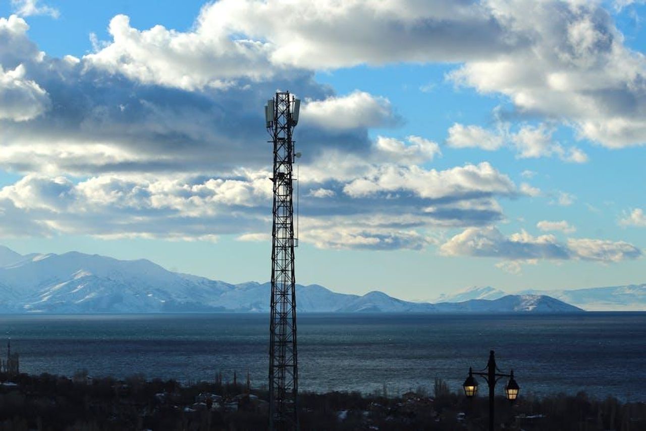 Innovazioni_nella_piattaforma_PBV_di_Kia_Hb77sLWkg0 - Veicoli24 Source: Şeyma Alkaş - pexels - Transmission tower by Lake Van with mountains and clouds in Türkiye.