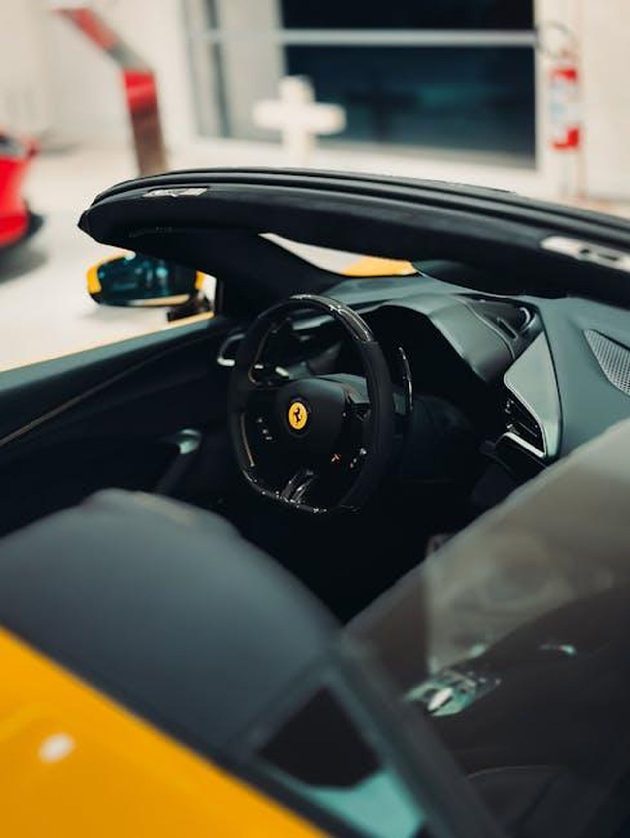 Interni_minimalisti_e_tecnologia_avanzata_MxlhOMujhR - Veicoli24 Source: Borta - pexels - Close-up of a sleek luxury convertible sports car interior in a modern setting.