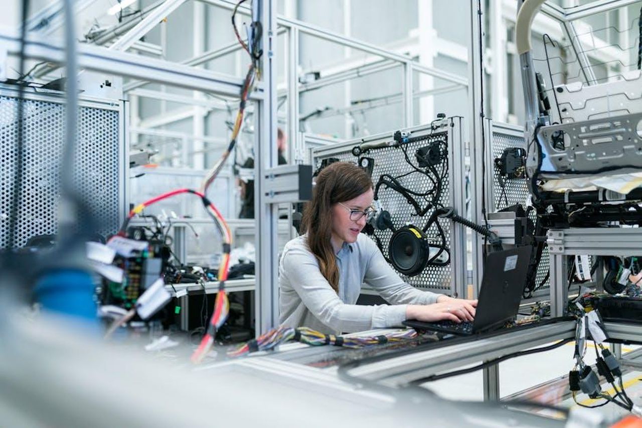 Knowhow_dalla_Baviera_e_dallAustria_richiesto_in_tutto_il_mondo_N1ltFFBNzI - Veicoli24 Source: ThisIsEngineering - pexels - A female engineer focuses on her laptop amidst advanced tech equipment in a lab.