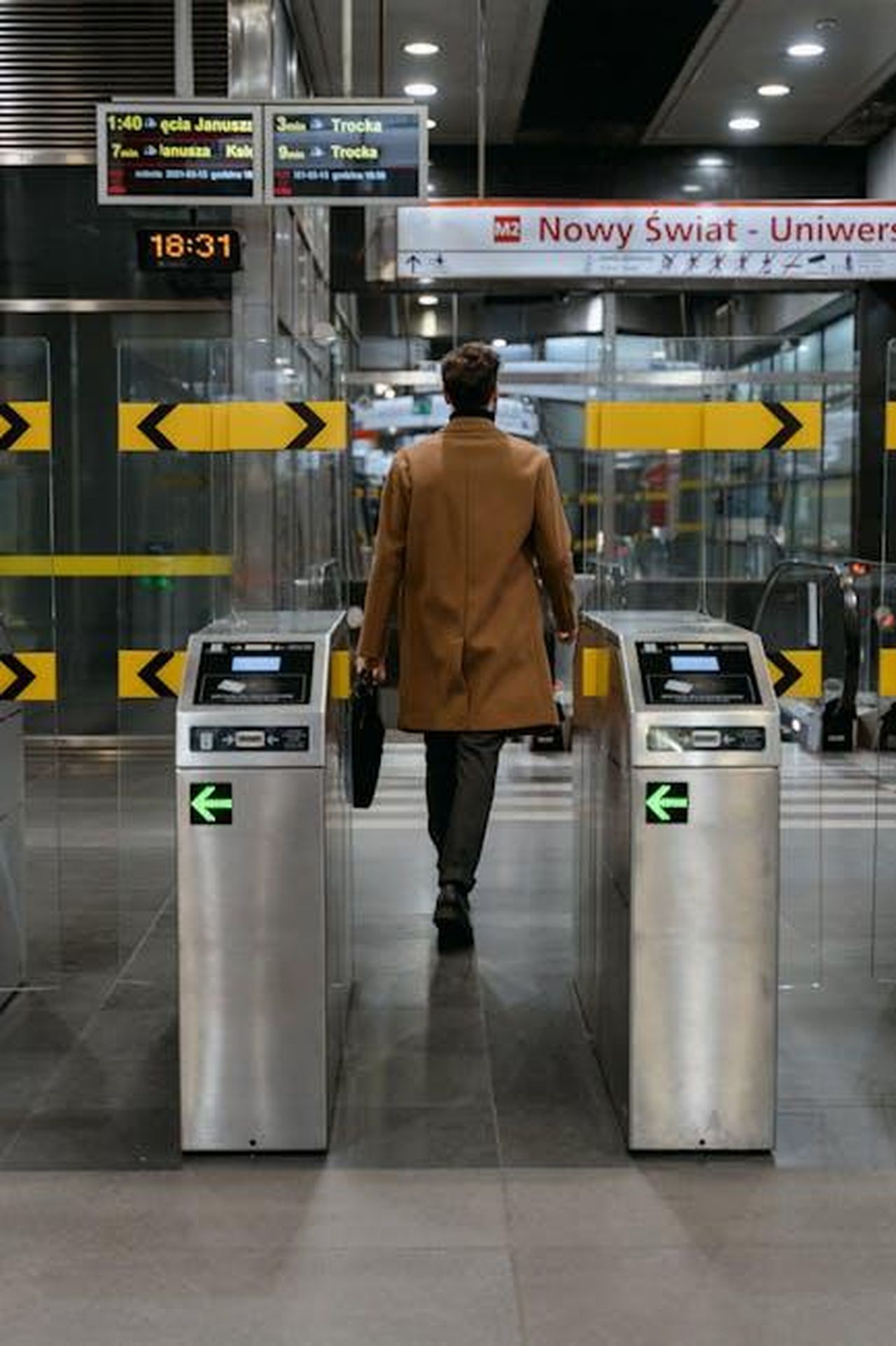La_transizione_verso_la_mobilit_elettrica_pzzWy7lcco - Veicoli24 Source: MART PRODUCTION - pexels - A businessman walks through a metro station ticket barrier in an urban setting.