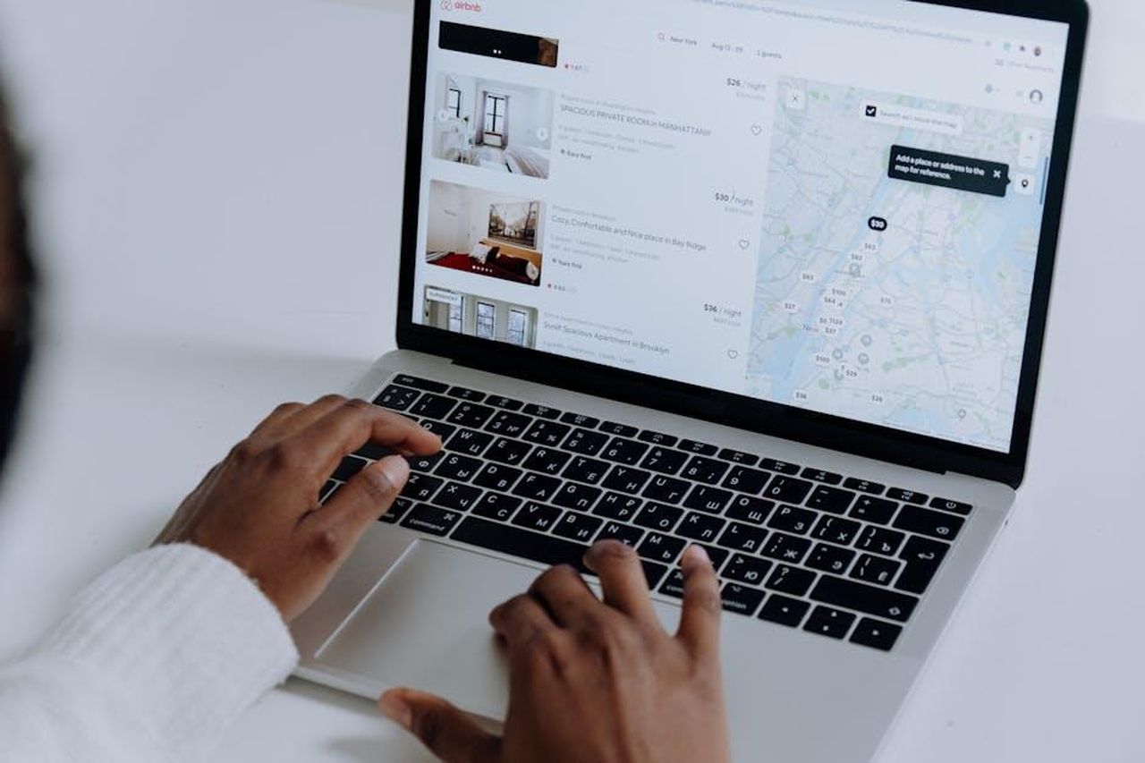 Le_prenotazioni_per_i_modelli_ibridi_superano_quelle_elettriche_vj2pGxqnmp - Veicoli24 Source: cottonbro studio - pexels - Hands typing on laptop searching Airbnb for accommodation options with map view.