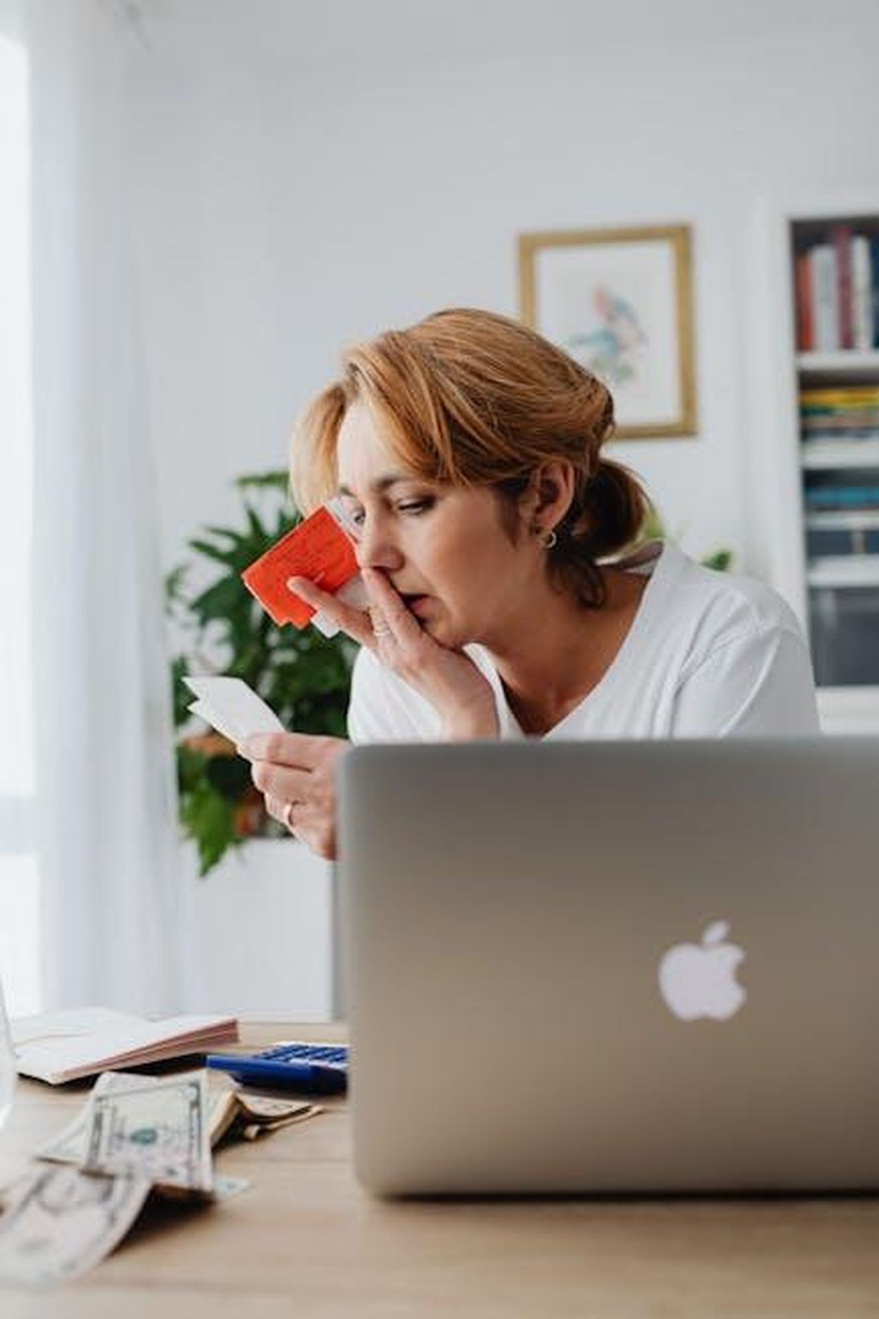 Le_sfide_finanziarie_per_i_garage_indipendenti_9EKqqC6CQj - Veicoli24 Source: Photo By: Kaboompics.com - pexels - Woman concerned over finances with laptop, card, and receipts. Indoor, modern home office setting.