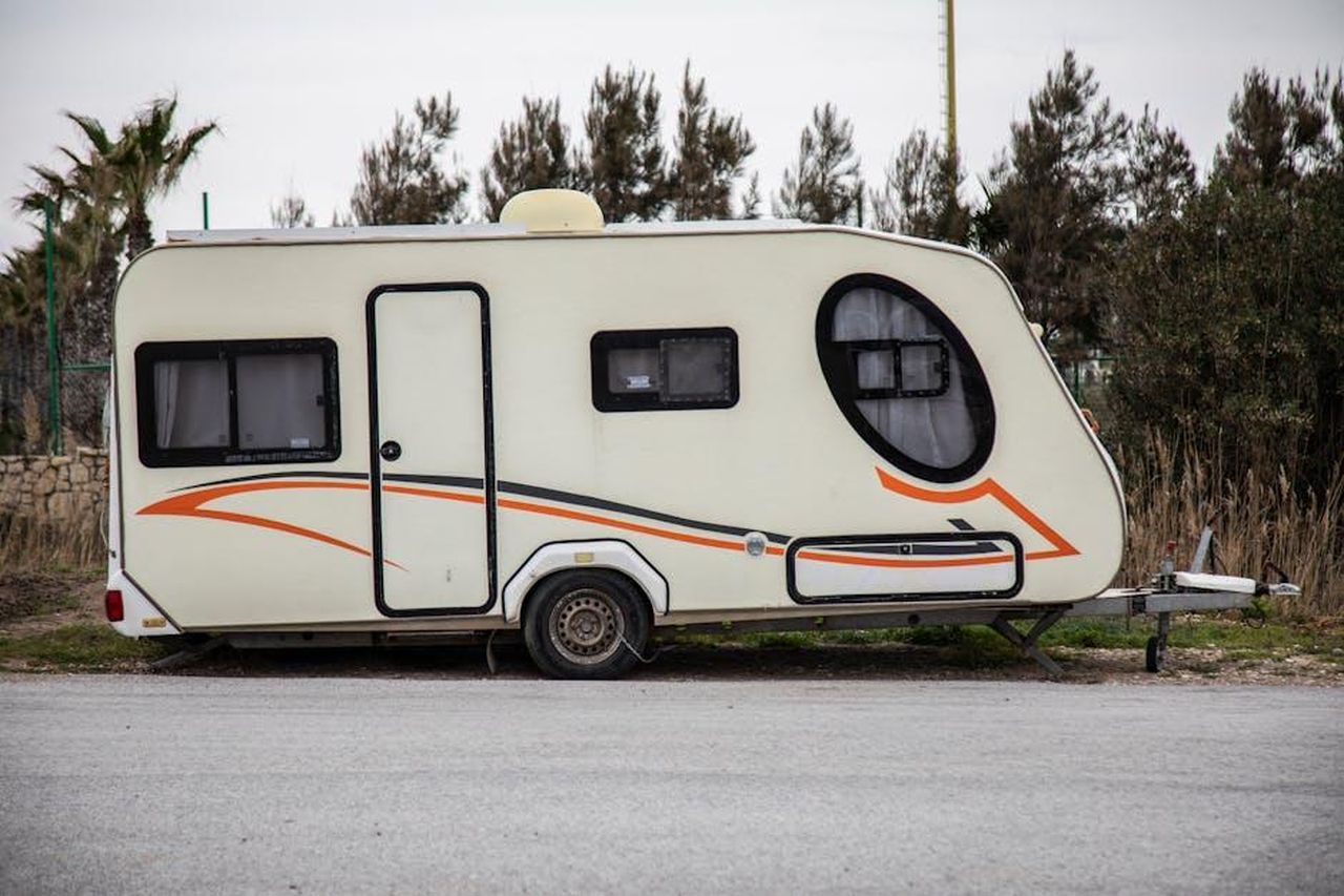 Limportanza_del_flattowing_per_i_proprietari_di_RV_74ioCIk0B3 - Veicoli24 Source: Engin Akyurt - pexels - A modern caravan parked outdoors, perfect for travel adventures.