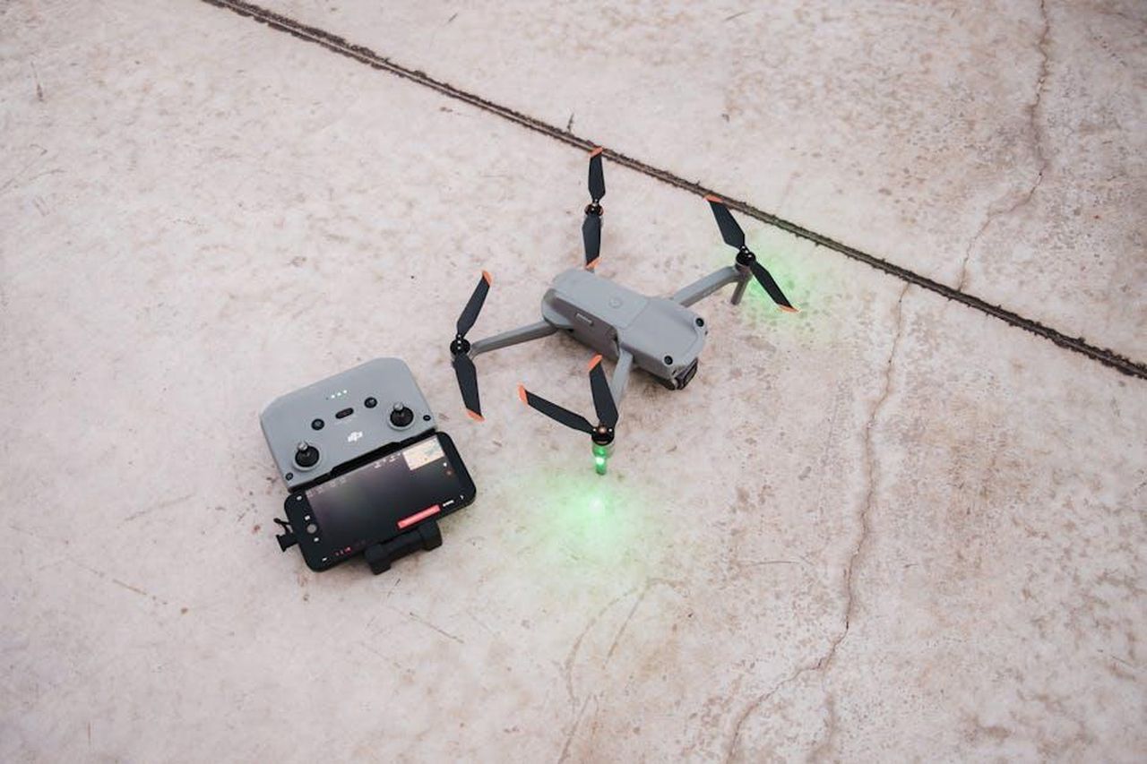 Modalit_di_lancio_per_unaccelerazione_rapida_Hc9rwDXa99 - Veicoli24 Source: Airam Dato-on - pexels - A close-up overhead view of a drone and controller on a concrete surface, showcasing technology.