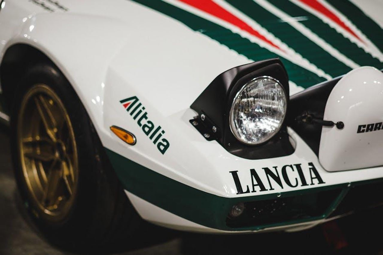 Modelli_in_evidenza_Lancia_Stratos_e_Delta_HF_Integrale_5EHuTSEwrJ - Veicoli24 Source: Mathias Reding - pexels - Detailed view of a Lancia Stratos sports car with Alitalia branding, showcasing its classic rally design.