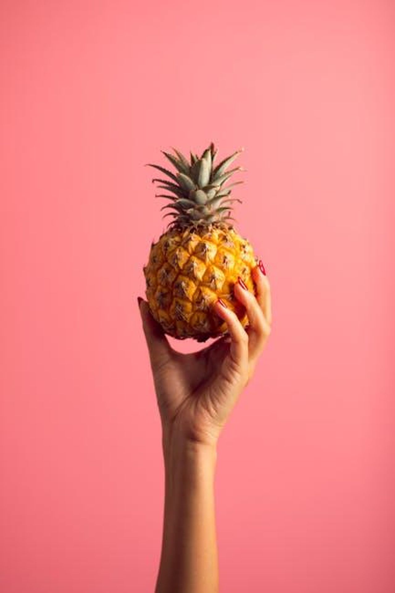 Motorizzazioni_e_aggiornamenti_per_il_Cayenne_attuale_k407uk2REp - Veicoli24 Source: Aleksandar Pasaric - pexels - A hand with polished nails holds a ripe pineapple against a vivid pink backdrop, embodying tropical freshness.