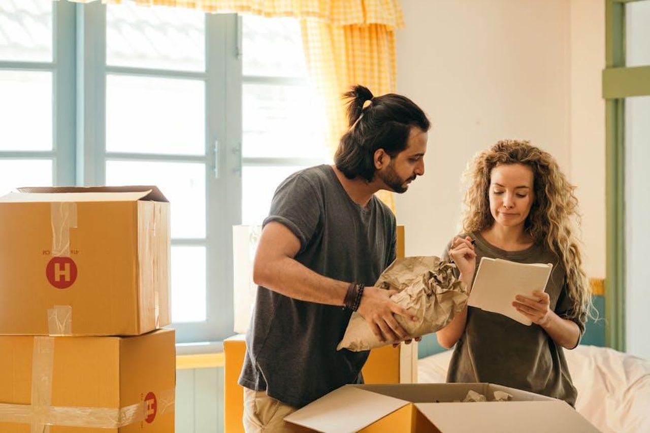 Nuove_partnership_e_sviluppo_di_modelli_ibridi_oZPfnccSxY - Veicoli24 Source: Ketut Subiyanto - pexels - Cheerful young man and woman smiling while unpacking carton boxes with belongings in new apartment during relocation and looking at paper