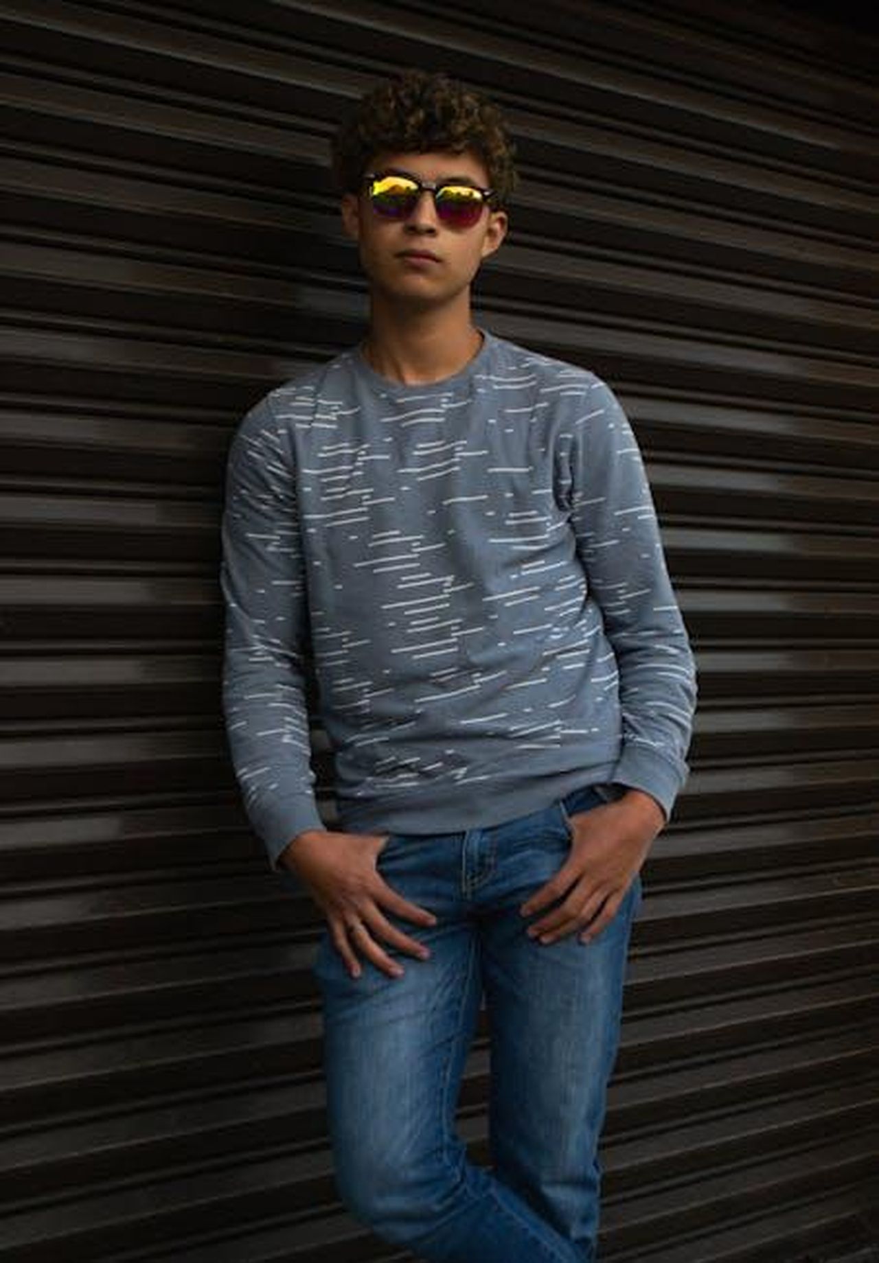 Offensiva_di_modelli_in_corso_di_Audi_GtNNTohm3M - Veicoli24 Source: Luis Fernando Aguilar Lopez - pexels - Teen boy in stylish casual outfit with sunglasses leaning on garage door.
