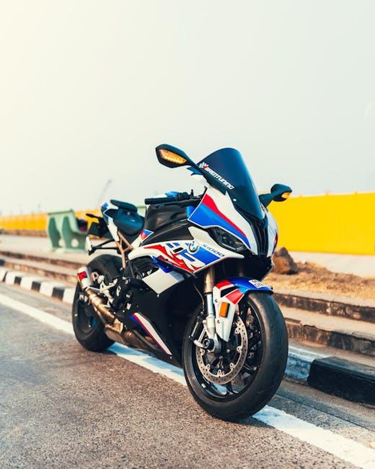 Panoramica_delle_attivit_di_BMW_Motorrad_Motorsport_nella_stagione_2025_7DdGda29fu - Veicoli24 Source: Ashwin Tambatkar - pexels - Dynamic shot of a high-performance sports motorcycle parked on a city road, showcasing sleek design and vibrant colors.