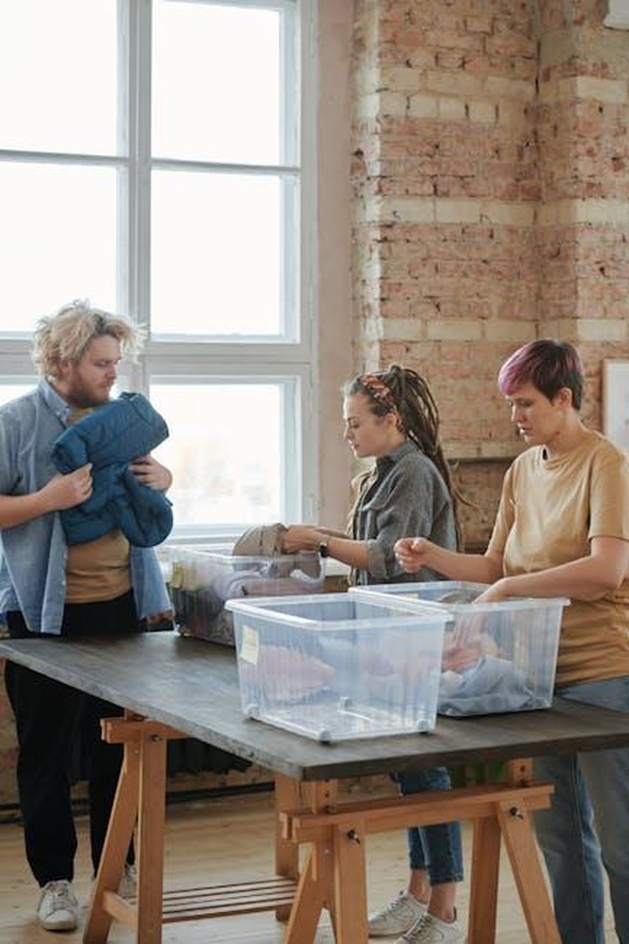 Pensare_globalmente_agire_localmente_1vpAwUe6rq - Veicoli24 Source: Julia M Cameron - pexels - Three volunteers sorting clothes indoors. Engaged in organizing for charity, teamwork, and community service.