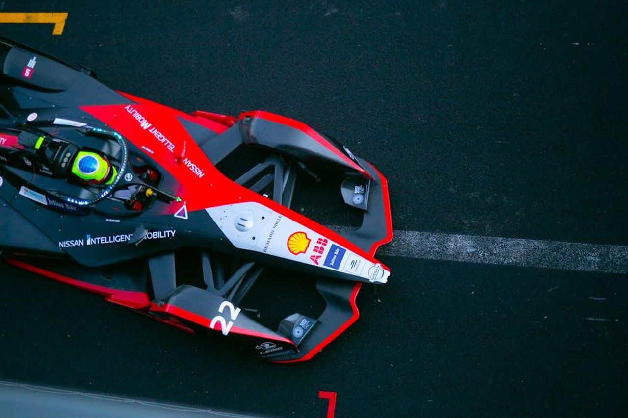 Performance_di_Norman_Nato_e_Gabriele_Min_E7ToHcroA6 - Veicoli24 Source: Alex wolf mx - pexels - A dynamic top view of a Formula E car racing on a track in Ciudad de México.