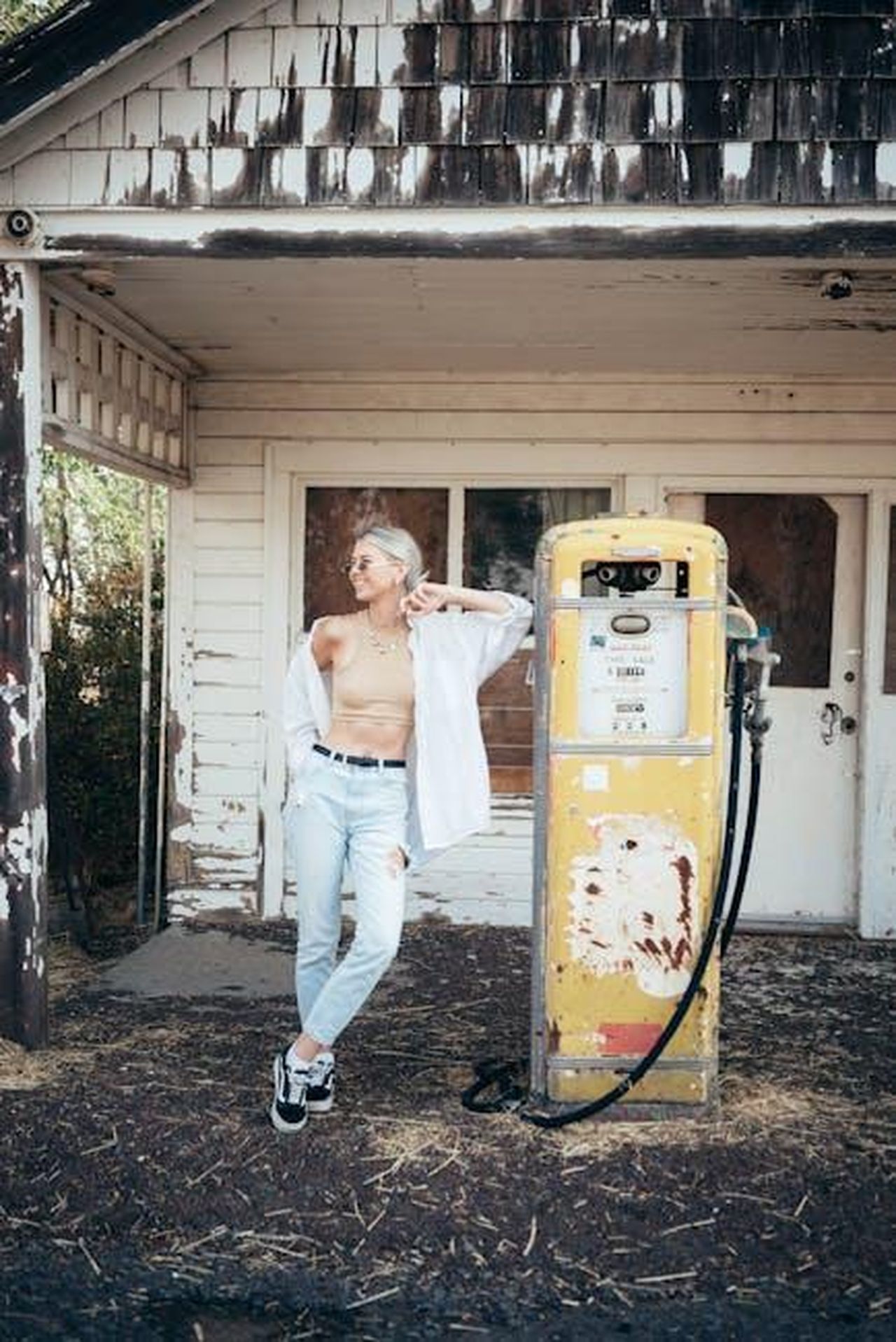 Piani_futuri_per_i_modelli_a_benzina_di_Mercedes_VDTbidFDMq - Veicoli24 Source: Dziana Hasanbekava - pexels - Stylish woman in casual wear poses at an old, rustic gas station, evoking a retro vibe.