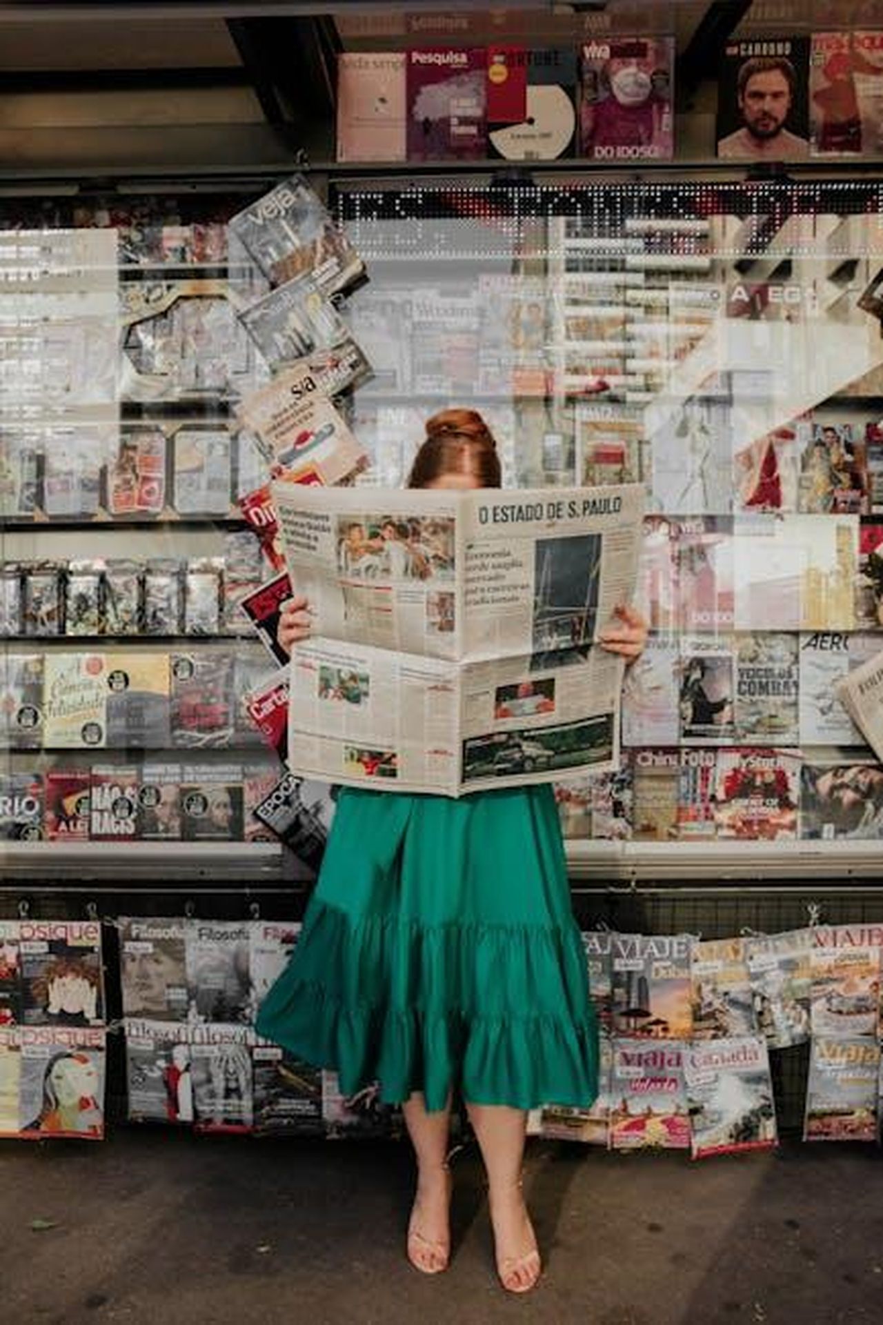 Possibili_aggiornamenti_futuri_per_la_Corvette_YRX5L2pf2t - Veicoli24 Source: Gabi Santana - pexels - Woman in green dress reading newspaper at street magazine stand outdoors.
