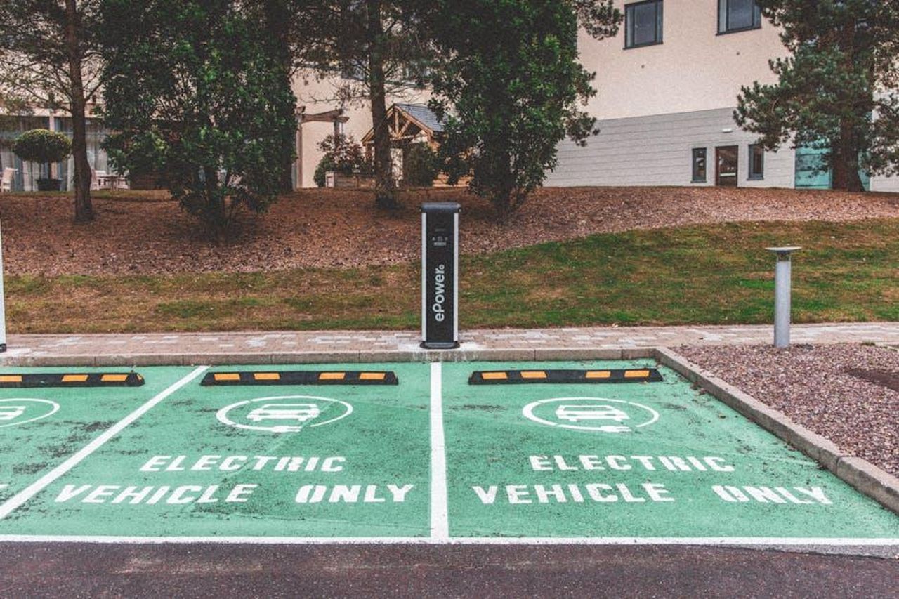 Preparazione_per_veicoli_elettrici_e_innovazioni_GMfejIUpKh - Veicoli24 Source: Craig Adderley - pexels - Green electric vehicle parking with charging station in urban environment.