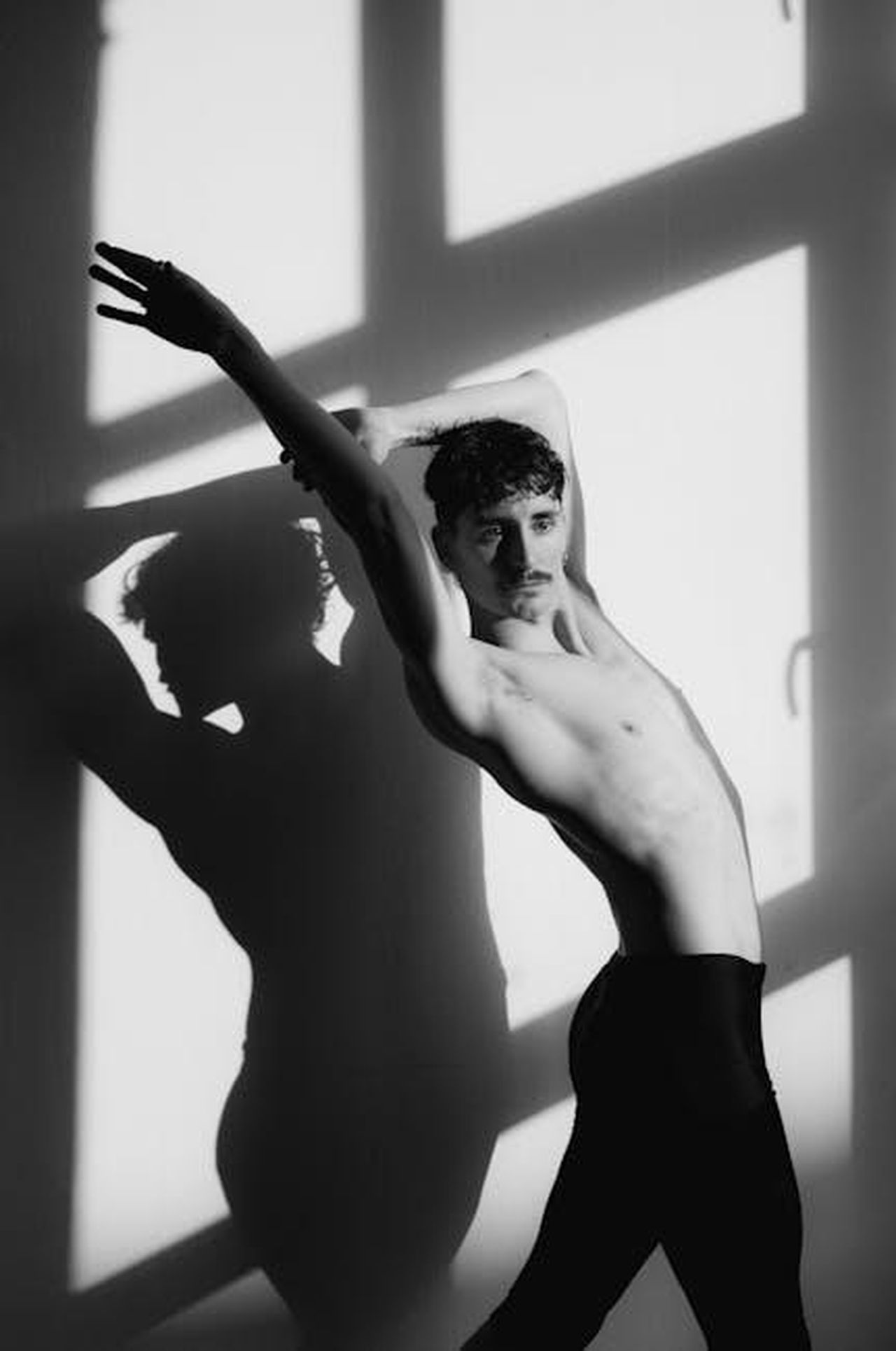Prestazioni_e_caratteristiche_tecniche_del_Prodrive_P25_pA5Bz6NdPP - Veicoli24 Source: Cathy B. - pexels - Artistic black and white photo of a male dancer striking a pose against a shadowed wall.