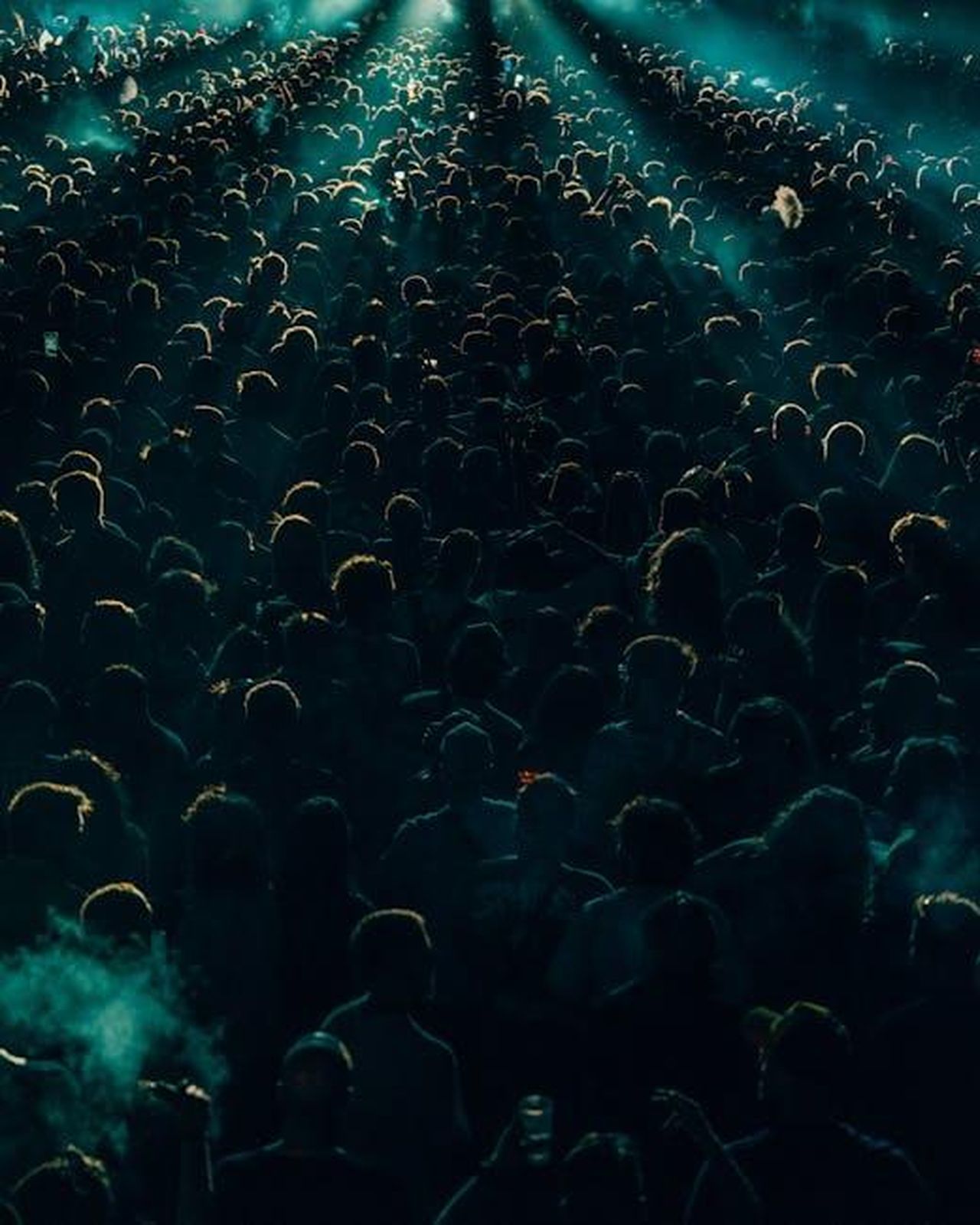 Prestazioni_e_motorizzazioni_del_R1T_e_R1S_9LGRr88FBo - Veicoli24 Source: Noland Live - pexels - A dense crowd enjoys a lively concert at night with dramatic lighting creating shadows and an energetic atmosphere.
