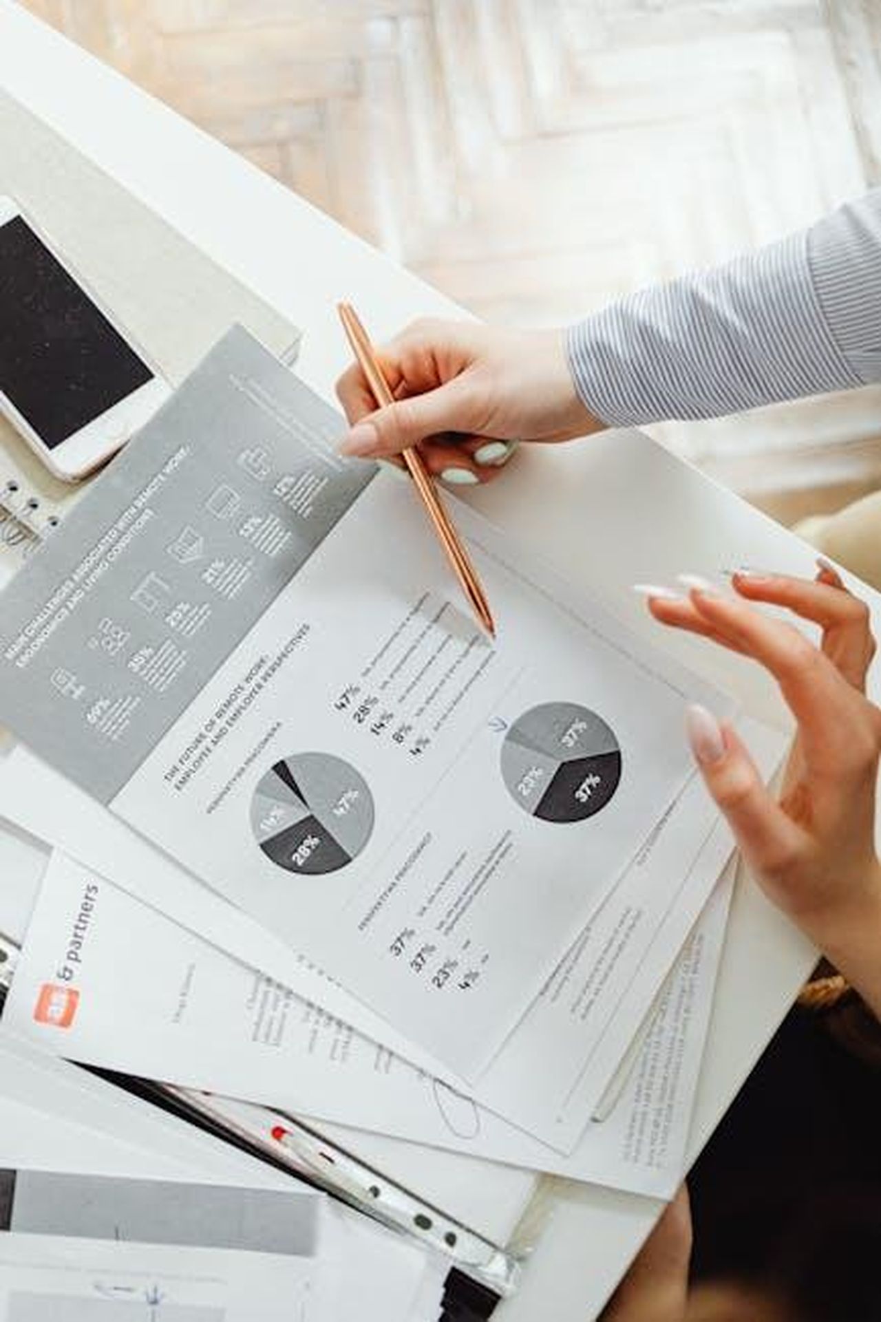 Previsioni_di_vendita_e_futuro_di_Mitsubishi_ei7Kuikb2O - Veicoli24 Source: Photo By: Kaboompics.com - pexels - Close-up of businesswoman analyzing financial reports using pie charts in an office setting.
