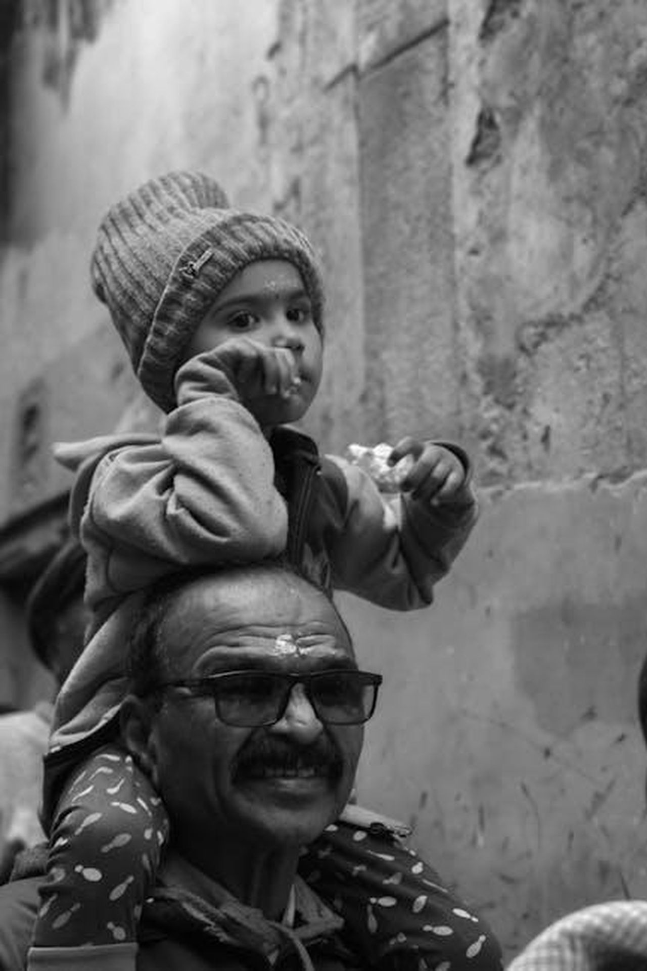Previsioni_sui_buyback_azionari_aOvnwlKGRN - Veicoli24 Source: Himanshu Singh - pexels - Black and white portrait of a child on a man's shoulders in Varanasi.