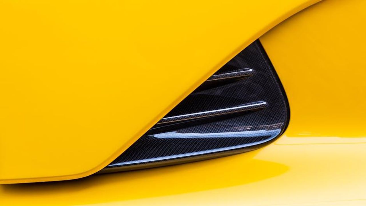 Prezzi_e_disponibilit_x6QjuTIOry - Veicoli24 Source: Quentin Martinez - pexels - Detailed view of a yellow supercar's carbon fiber vent design for sleek performance aesthetics.