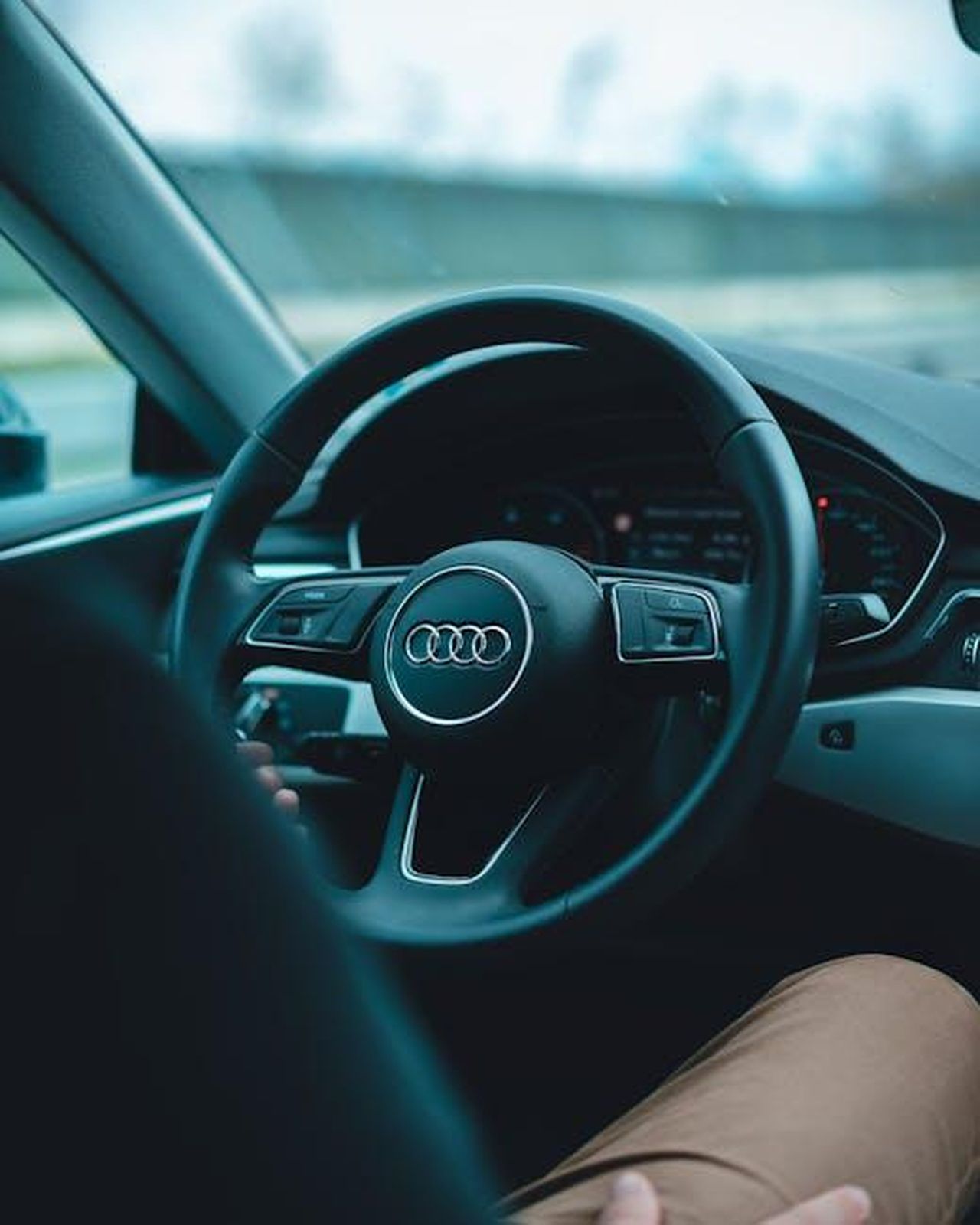 Prezzo_base_della_nuova_Audi_A5_2025_uOtfnLOjxh - Veicoli24 Source: Guillaume Meurice - pexels - Interior view of a man driving an Audi with focus on steering wheel and dashboard.