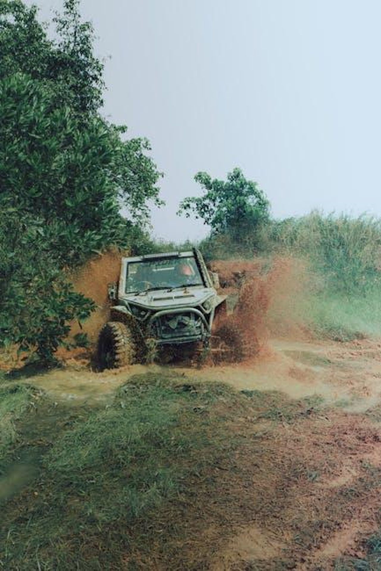 Prezzo_e_disponibilit_del_Jeep_Wrangler_4xe_Backcountry_TQLeJ6QvOY - Veicoli24 Source: Sleeba Thomas - pexels - An off-road vehicle splashes through a muddy path in a forest setting, showcasing adventure and rugged terrain.