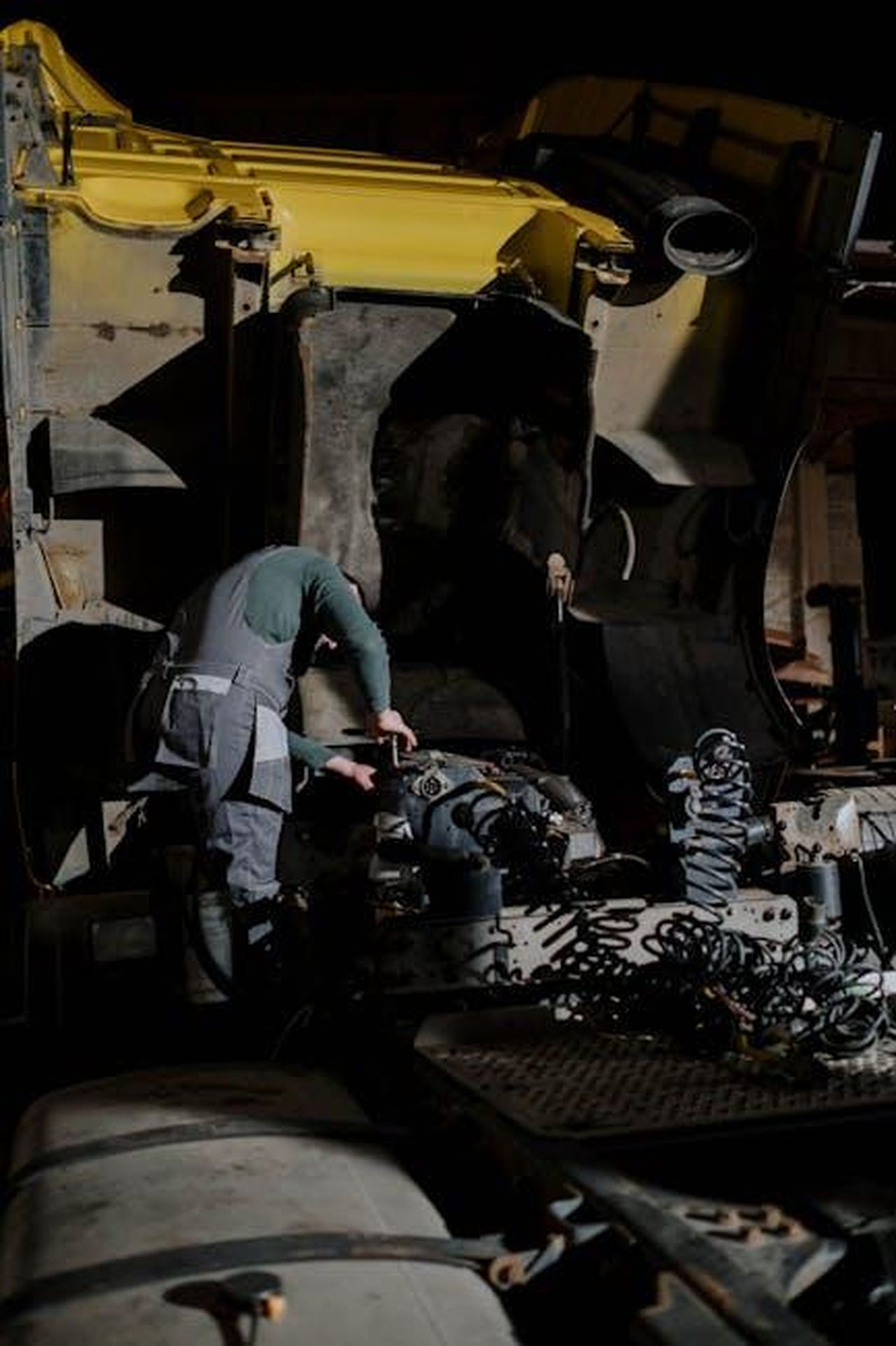 Problemi_causati_dalle_fasce_elastiche_dei_pistoni_DgaGLRqc2I - Veicoli24 Source: cottonbro studio - pexels - Mechanic working on a truck engine repair at night in a dimly lit garage.