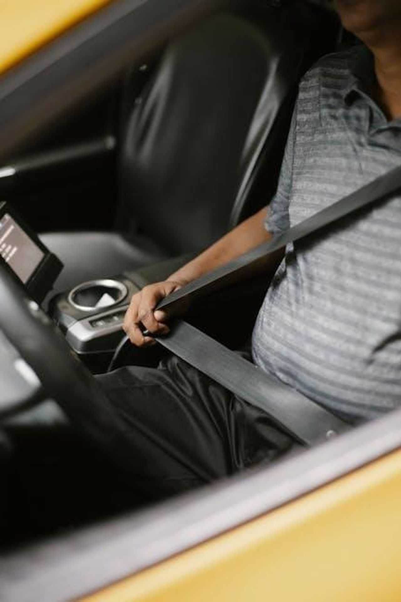Problemi_con_i_bulloni_delle_cinture_di_sicurezza_EBHQp3ZmZs - Veicoli24 Source: Tim Samuel - pexels - From above of crop unrecognizable male driver fastening seat belt while sitting in car in daytime
