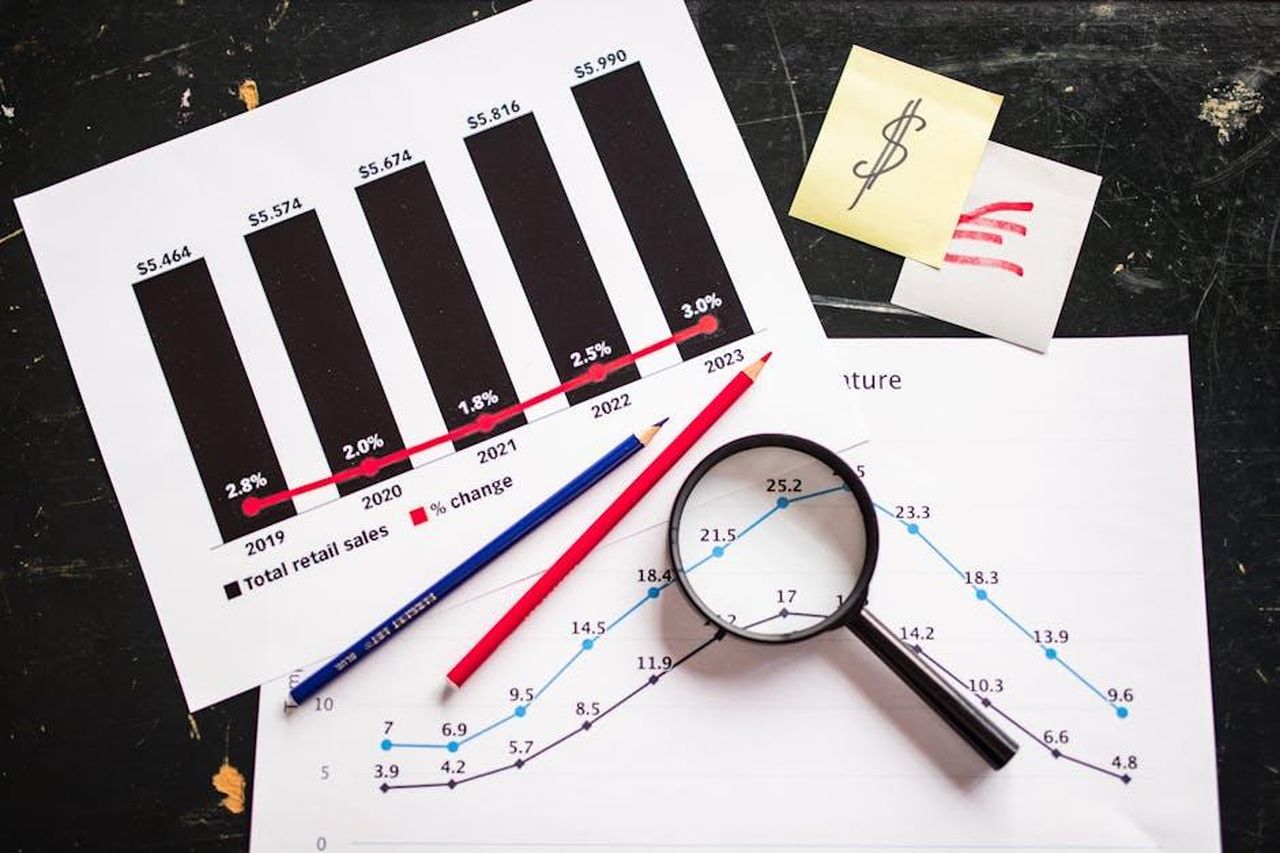 Profitti_dei_rivenditori_e_prezzi_di_transazione_KMkYg7AKpN - Veicoli24 Source: RDNE Stock project - pexels - Charts and graphs highlighting retail sales growth, utilizing a magnifying glass for detail.