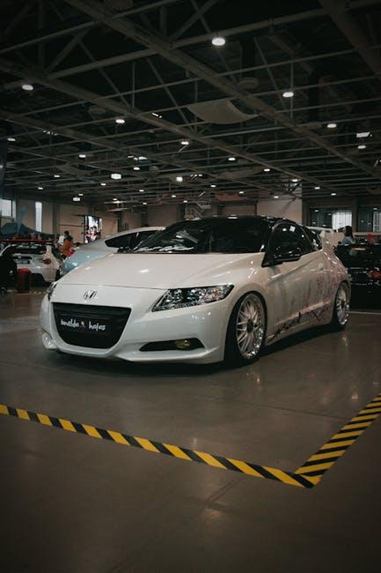 Prospettive_di_vendita_per_ibridi_e_veicoli_elettrici_8fmtZ6EvOv - Veicoli24 Source: Molnár Tamás Photography™ - pexels - A sleek Honda CR-Z hybrid showcased at an automotive exhibition in Hungary, highlighting modern car design.