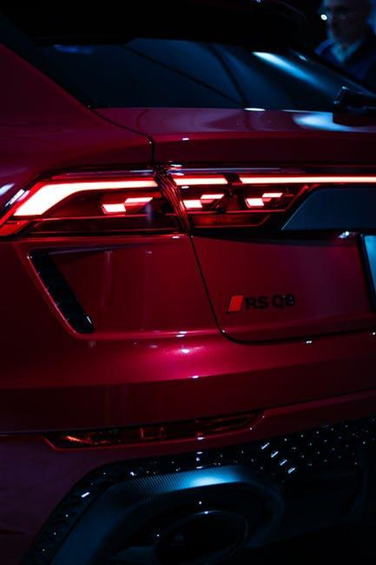 Punti_di_forza_lbM7gYngbv - Veicoli24 Source: Anurag Jamwal - pexels - Close-up shot of a red Audi RS Q8 showcasing its sleek tail lights in a moody studio setting.