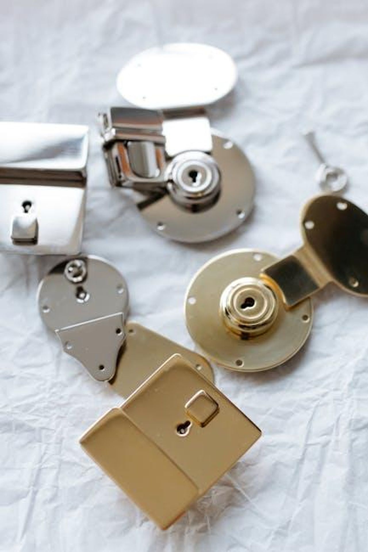 Raccomandazioni_per_ridurre_la_criminalit_veicolare_7IXyS8owwh - Veicoli24 Source: cottonbro studio - pexels - Detailed shot of different metal locks and a key on a textured surface, highlighting security.