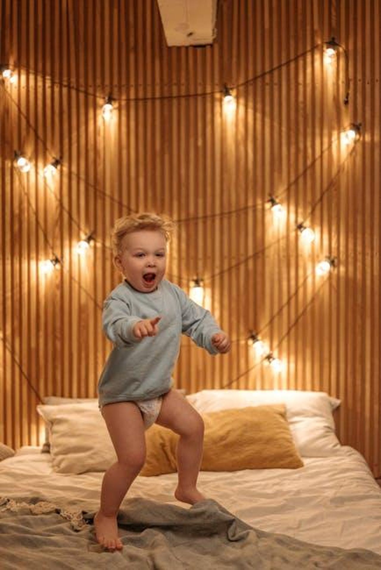 Recupero_energetico_e_aumento_dellefficienza_del_25_q1TtEjwBO2 - Veicoli24 Source: Pavel Danilyuk - pexels - A joyful child plays on a bed decorated with string lights, creating a cozy atmosphere.