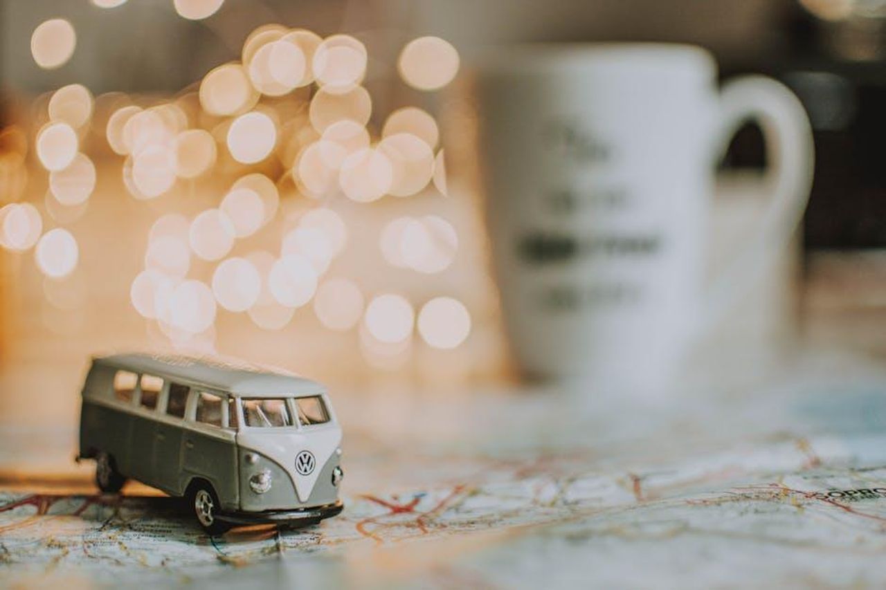 Richieste_chiave_dal_Piano_per_i_Furgoni_a_Zero_Emissioni_P9QinfsYYn - Veicoli24 Source: lil artsy - pexels - A close-up of a vintage toy Volkswagen on a map with bokeh lights and coffee cup in the background.