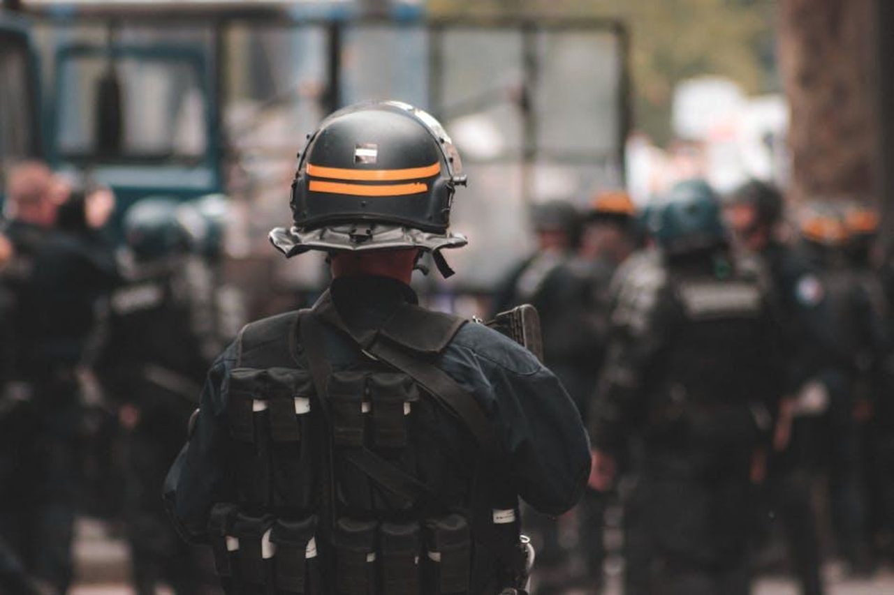 Rischi_associati_e_segnalazioni_ricevute_xALHm2GzK7 - Veicoli24 Source: Mathias Reding - pexels - Back view of anonymous policeman in helmet and bulletproof vest maintaining law and order while standing on city street