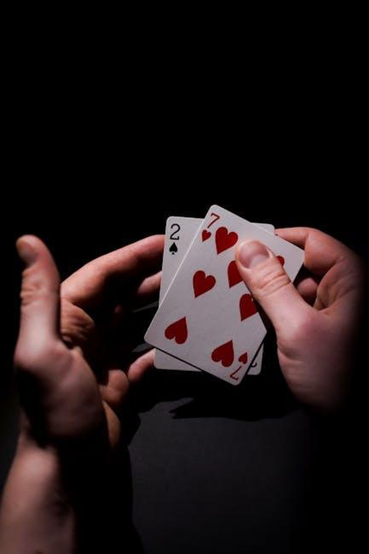 Rischi_per_le_banche_di_medie_dimensioni_nel_finanziamento_auto_4YMKF5qs80 - Veicoli24 Source: Anastasiya Badun - pexels - Intense close-up of poker cards in a player's hand, highlighting the suspense of gambling.