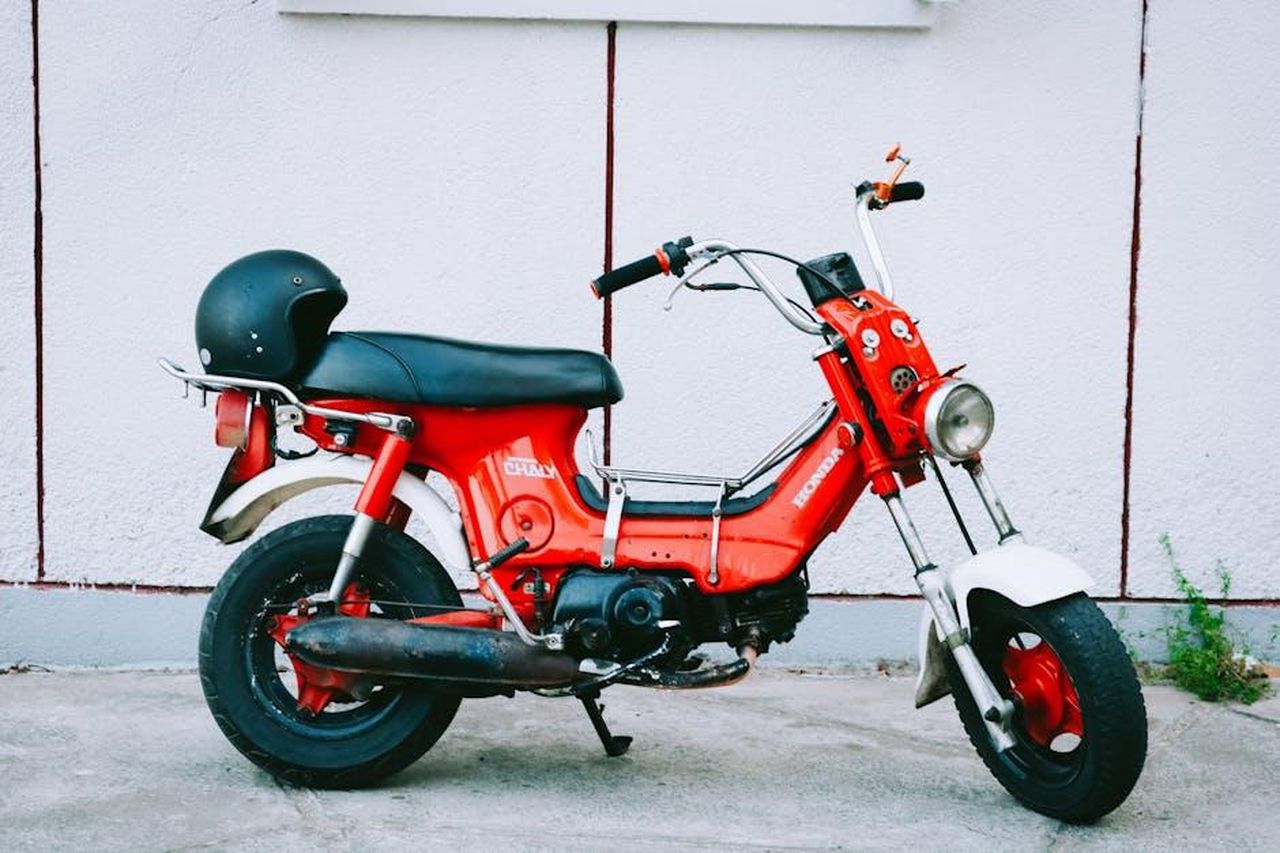 Sicurezza_della_Honda_Odyssey_2025_0kiuhHg1Be - Veicoli24 Source: Loifotos - pexels - Classic red Honda Chaly motorbike parked against a wall in Vietnam.