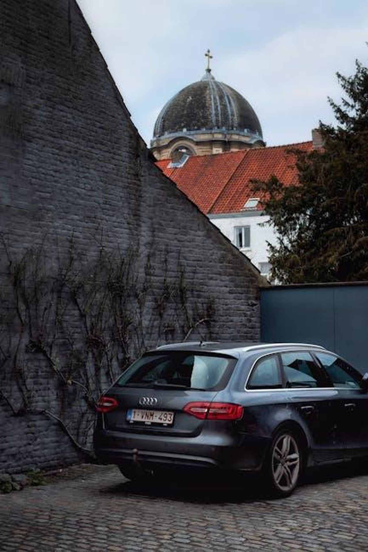 Storia_e_innovazione_dellAudi_A6_Avant_UrG1Iifi6u - Veicoli24 Source: Adam B. - pexels - Audi parked near a cobblestone street and historic church in Bruges, Belgium.