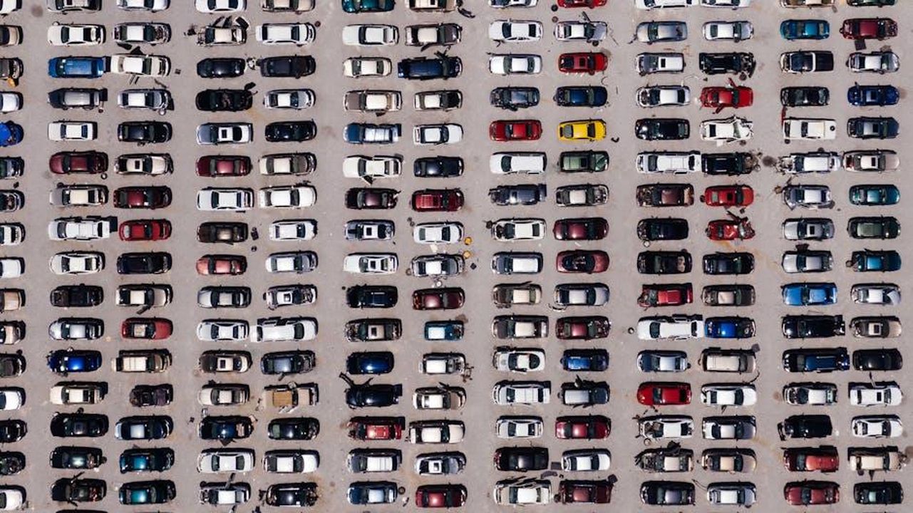 Strategia_di_Unite_per_il_mandato_ZEV_3yn298xkZ8 - Veicoli24 Source: Kelly - pexels - Top-down aerial shot of a large parking lot filled with rows of cars, showcasing organized symmetry.