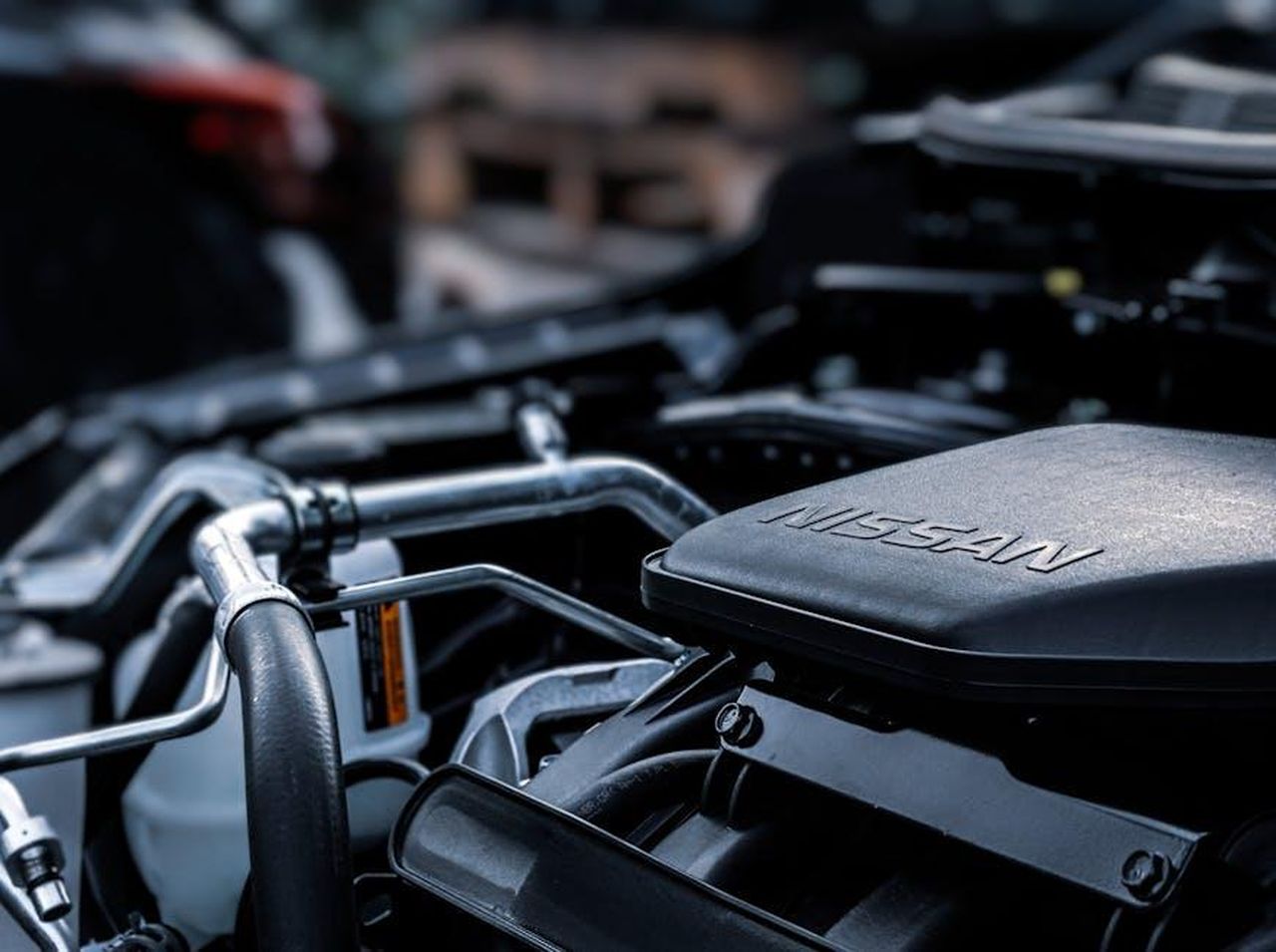 Sviluppo_del_sistema_a_celle_a_combustibile_di_Toyota_altNLlBAs7 - Veicoli24 Source: Obi Onyeador - pexels - Detailed view of a car engine compartment with visible Nissan branding.