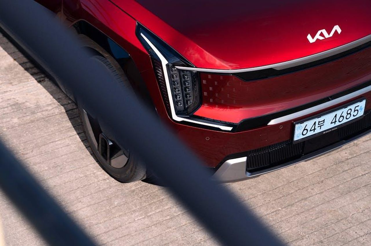 Sviluppo_e_futuro_del_Kia_PV5_REQfcrGLrp - Veicoli24 Source: Hyundai Motor Group - pexels - Close-up of a red Kia EV9 electric SUV on a concrete surface, showcasing the front design.