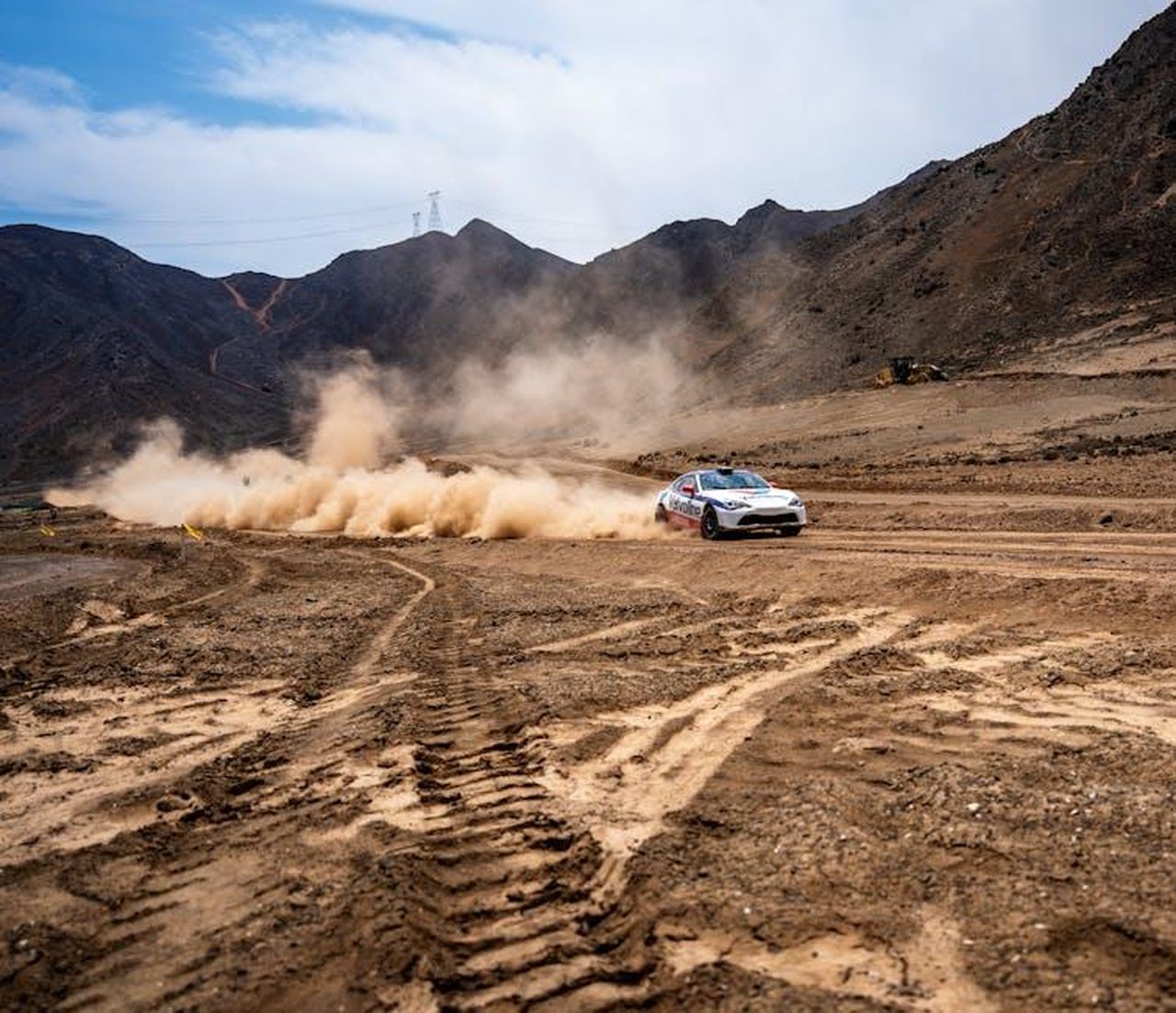Tariffe_automobilistiche_la_posizione_di_Trump_a1HgOMSf3H - Veicoli24 Source: Joaquin Delgado - pexels - Rally car speeding through a dusty mountain trail, capturing the thrill of off-road racing.