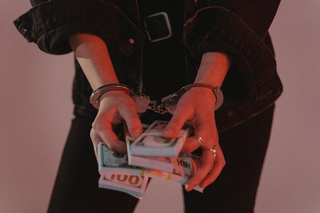 Un_deterrente_semplice_ma_efficace_XmhS5SzBXK - Veicoli24 Source: Tima Miroshnichenko - pexels - Close-up of hands holding cash with handcuffs, symbolizing crime and punishment.