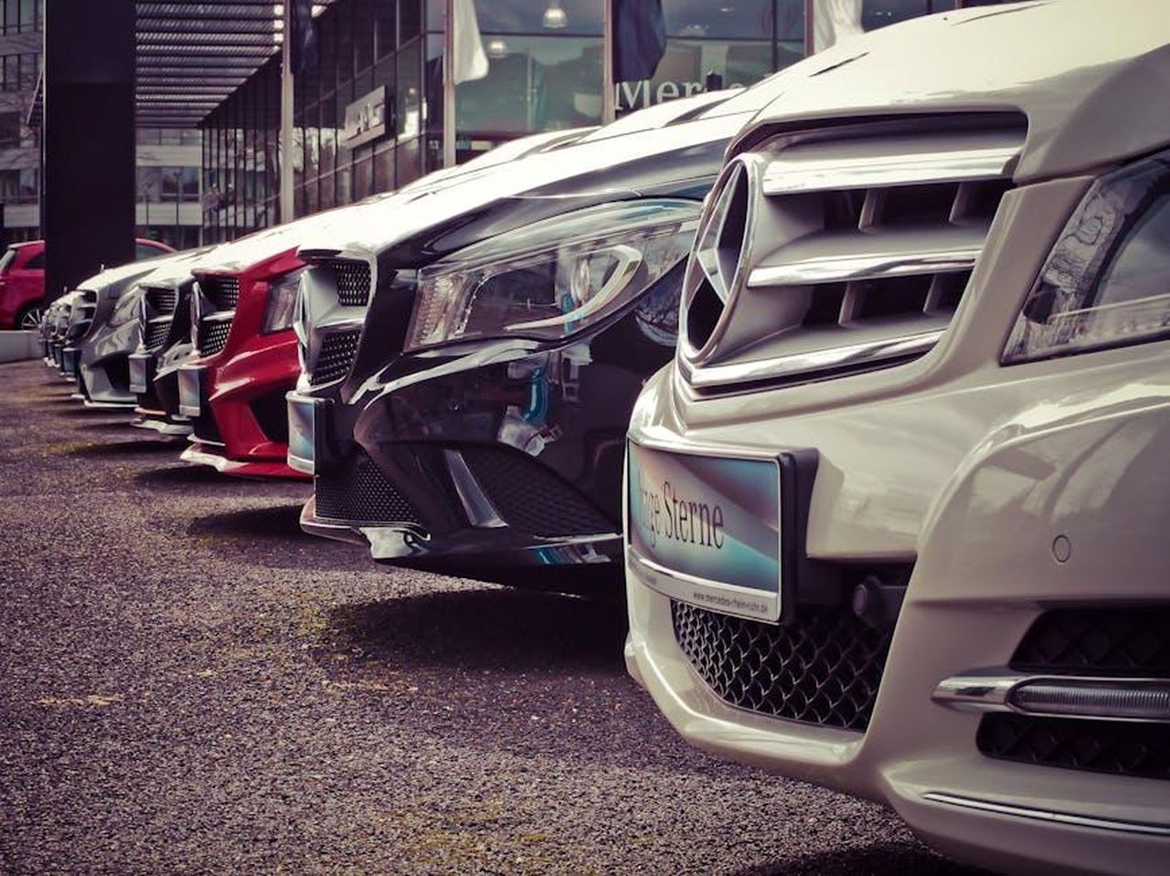 Vantaggi_per_i_concessionari_e_i_venditori_privati_xi0AJWZHgV - Veicoli24 Source: Pixabay - pexels - Luxury cars lined up at an outdoor dealership, showcasing sleek designs.
