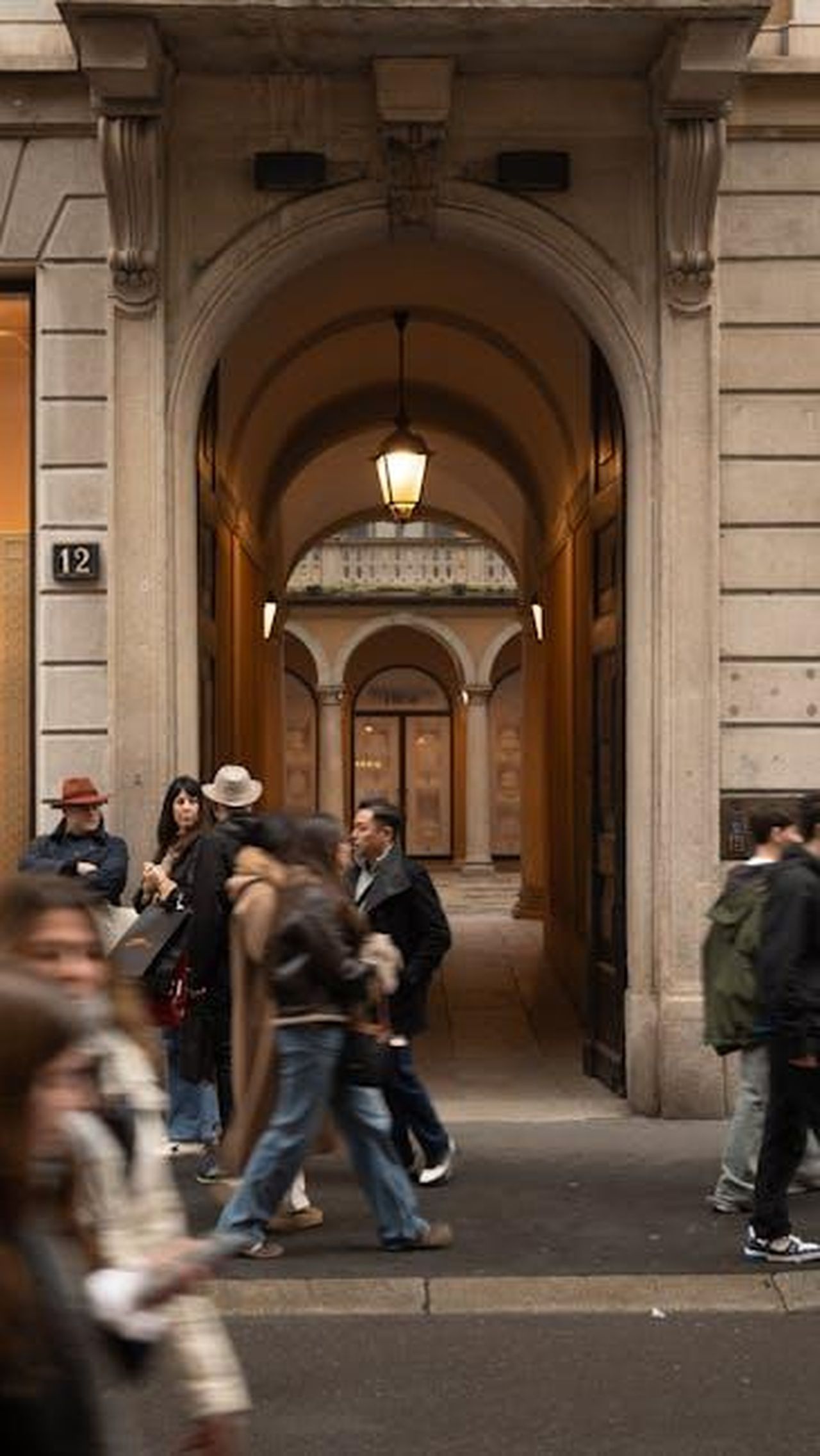 Varianti_del_Techart_Magnum_I2hOYMSdYS - Veicoli24 Source: Ciro Palomba - pexels - A stylish urban street scene with people walking past a grand architectural archway.