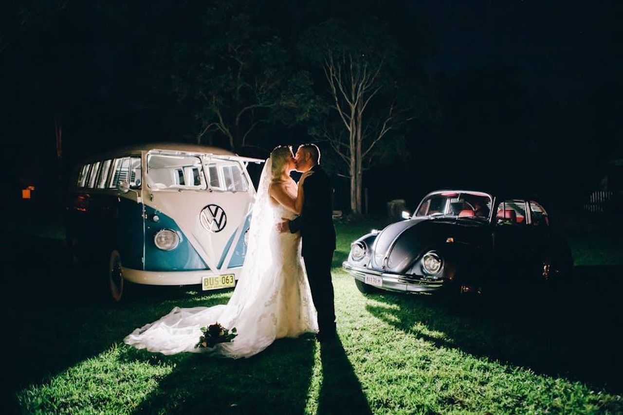 Veicoli_specializzati_e_rapporti_BCA_Assured_ABlvIWFCUk - Veicoli24 Source: Elegant Images - pexels - A bride and groom share a kiss beside vintage VW cars during a rustic nighttime wedding in Australia.