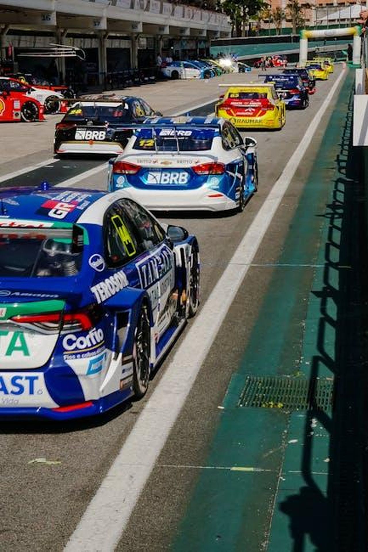 Adattabilit_delle_linee_guida_a_diversi_contesti_ZlEOOnD5VX - Veicoli24 Source: Caio Renato de Campos - pexels - Touring cars lined up at the pit lane during a thrilling race event on a sunny day.